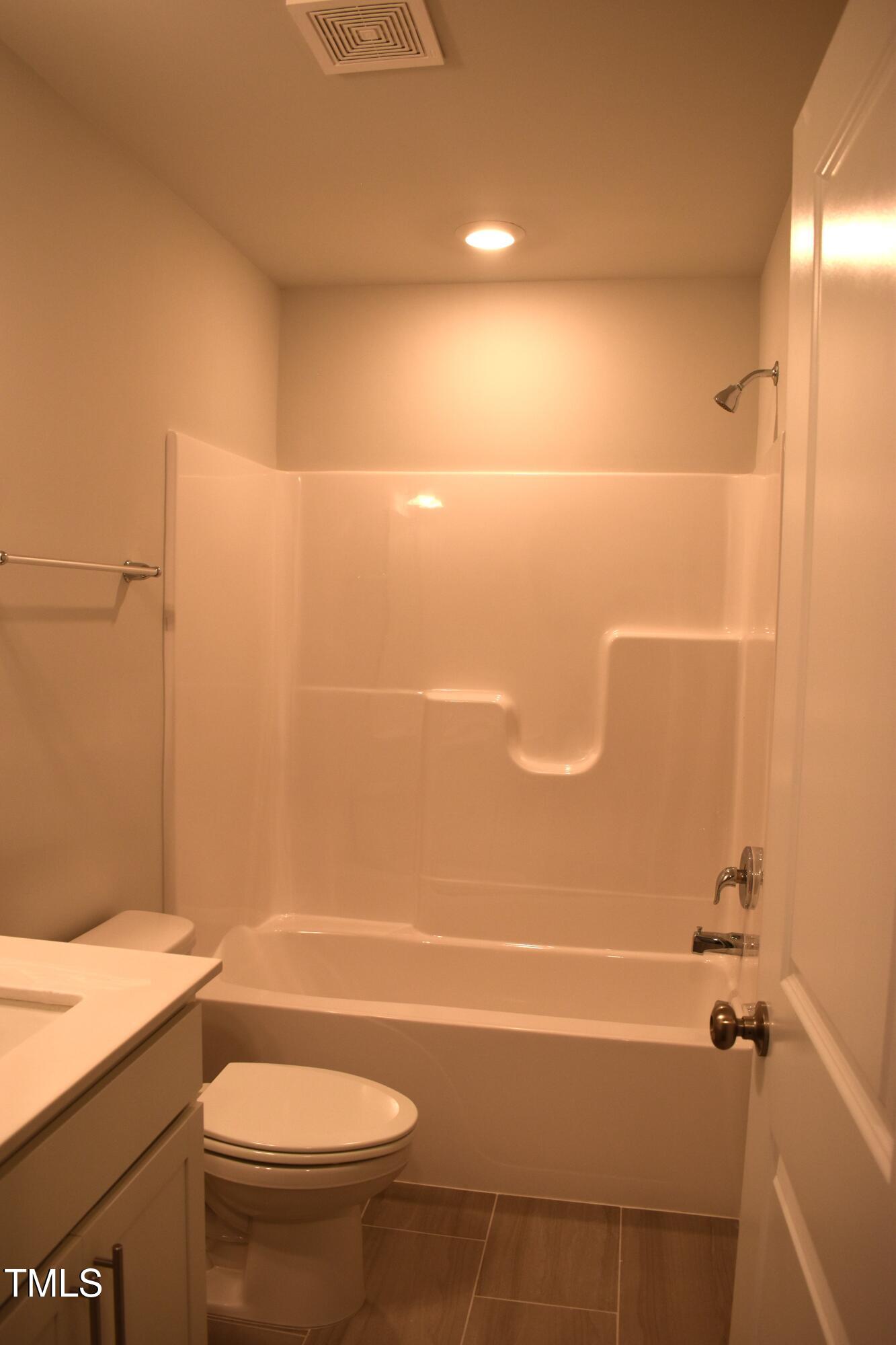 301 Deercroft Drive Apex, NC 27539 - Photo 9 of 33 a bathroom with a granite countertop bathtub shower sink vanity and toilet