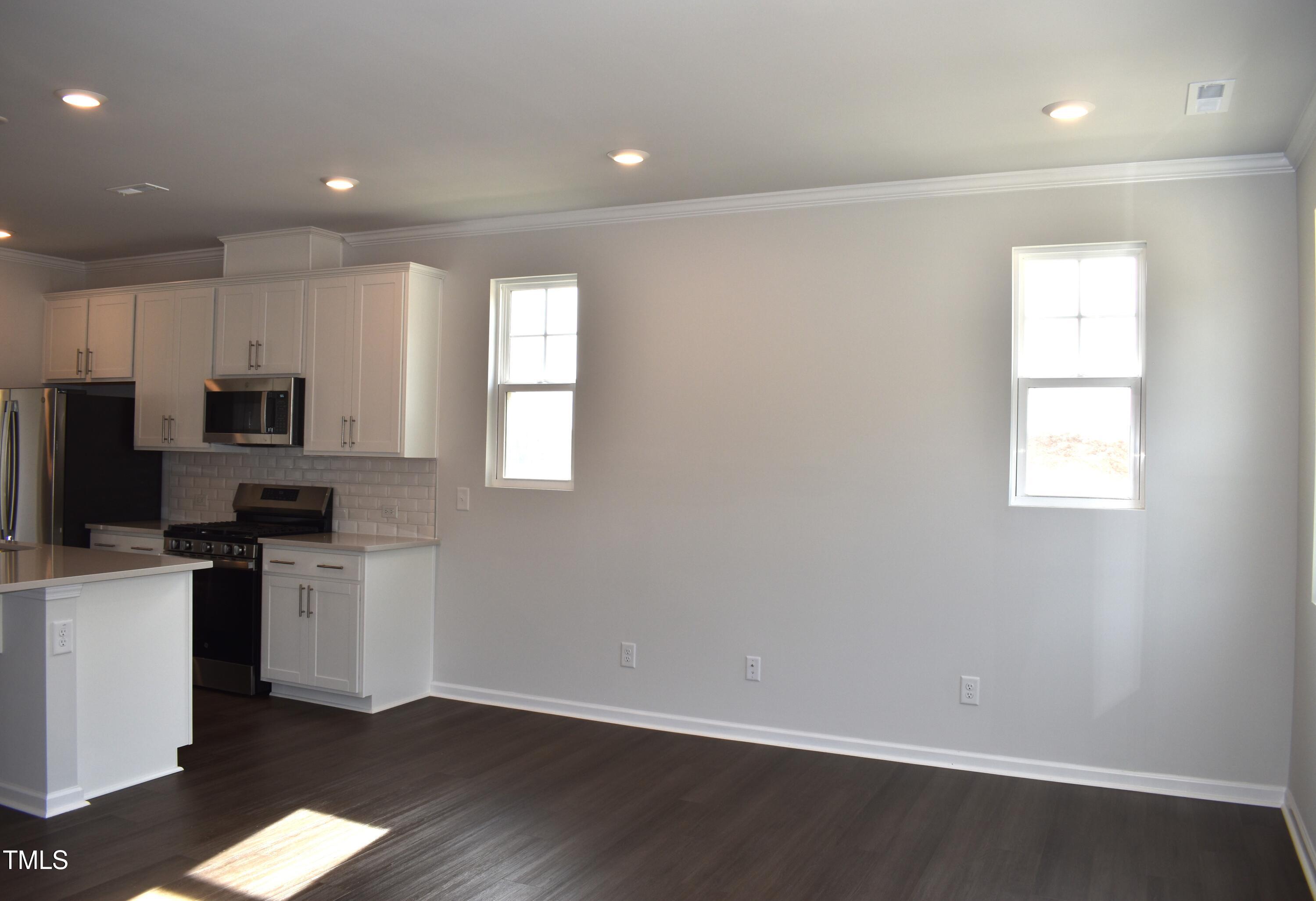 301 Deercroft Drive Apex, NC 27539 - Photo 10 of 33 a kitchen with stainless steel appliances a stove top oven a sink a refrigerator a window