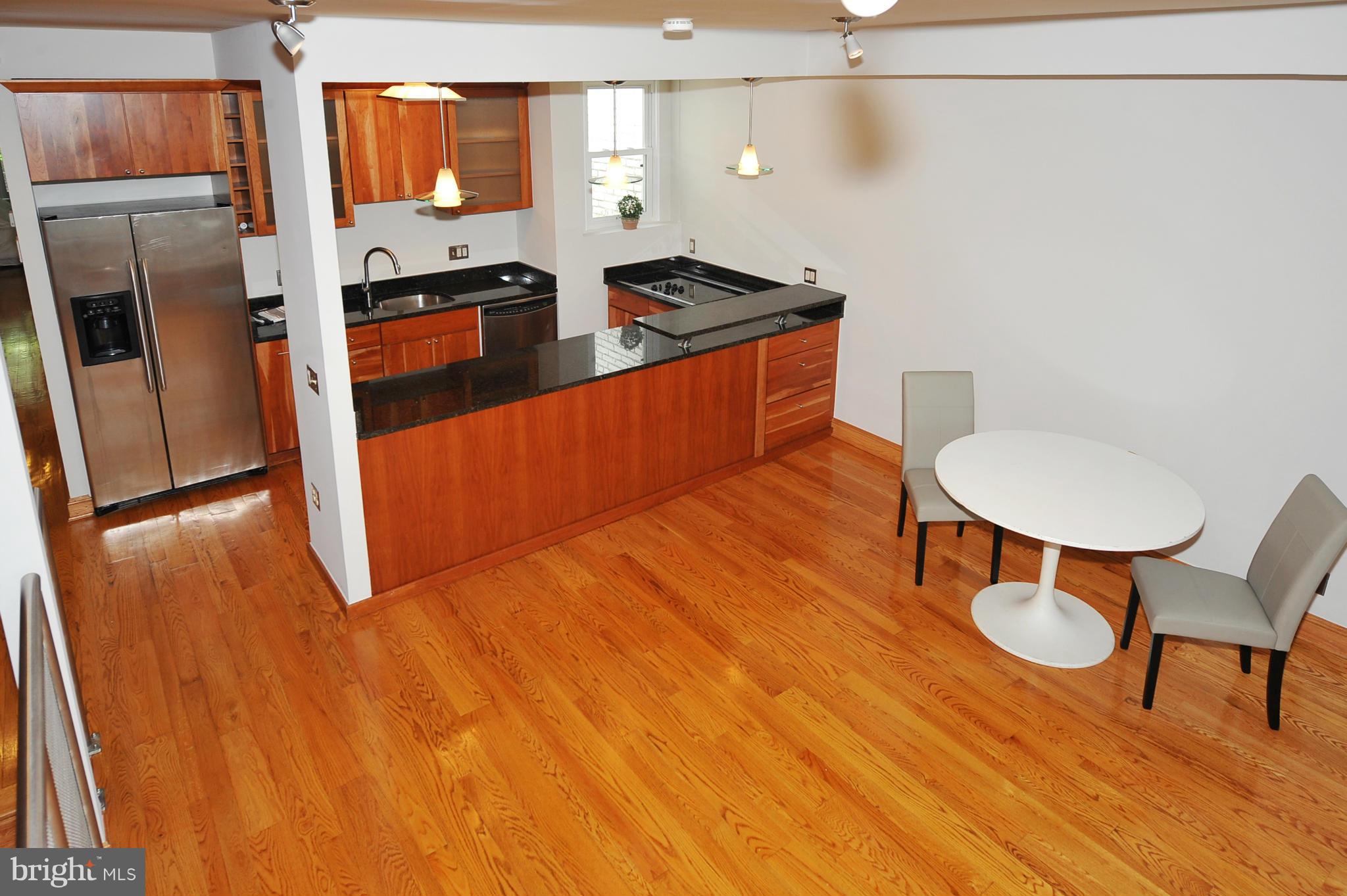 2509 17th Street Northwest, Unit 3 Washington, DC 20009 - Photo 19 of 27 a kitchen with stainless steel appliances granite countertop a sink a stove a refrigerator a dining table and chairs