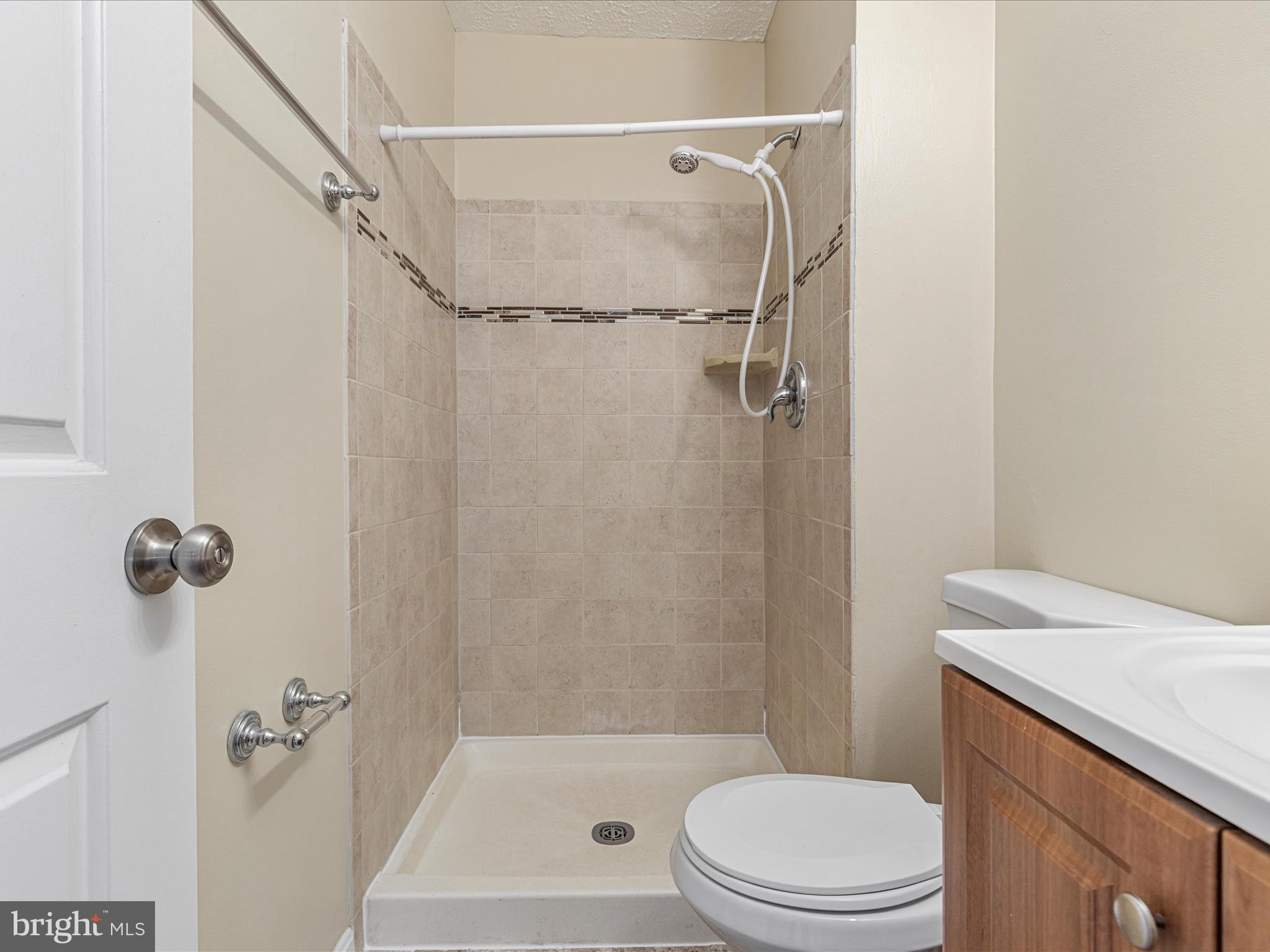7219 Kousa Lane Springfield, VA 22152 - Photo 19 of 34 a bathroom with a shower a toilet and a shower