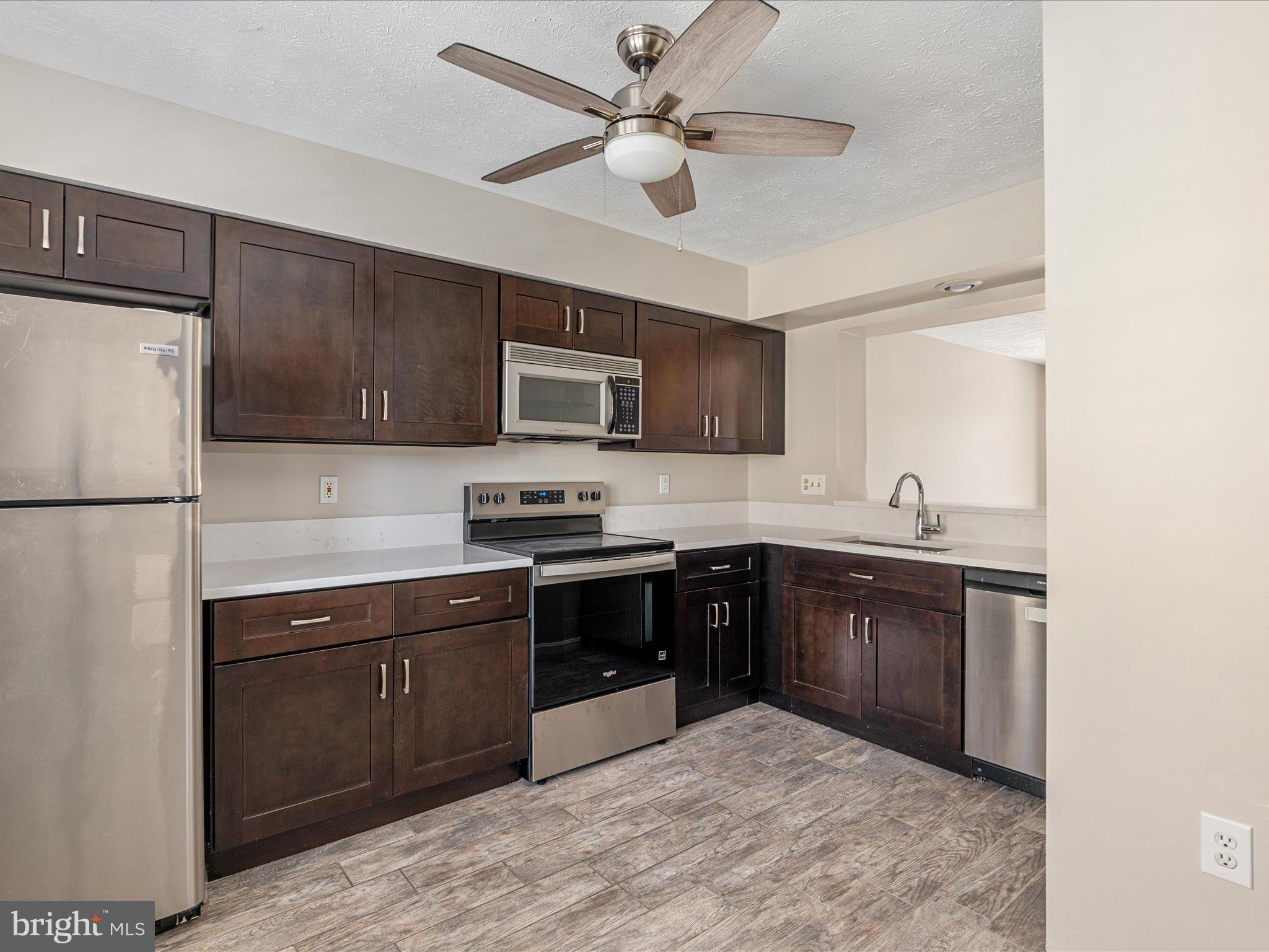 7219 Kousa Lane Springfield, VA 22152 - Photo 5 of 34 a kitchen with stainless steel appliances granite countertop a stove sink microwave and refrigerator