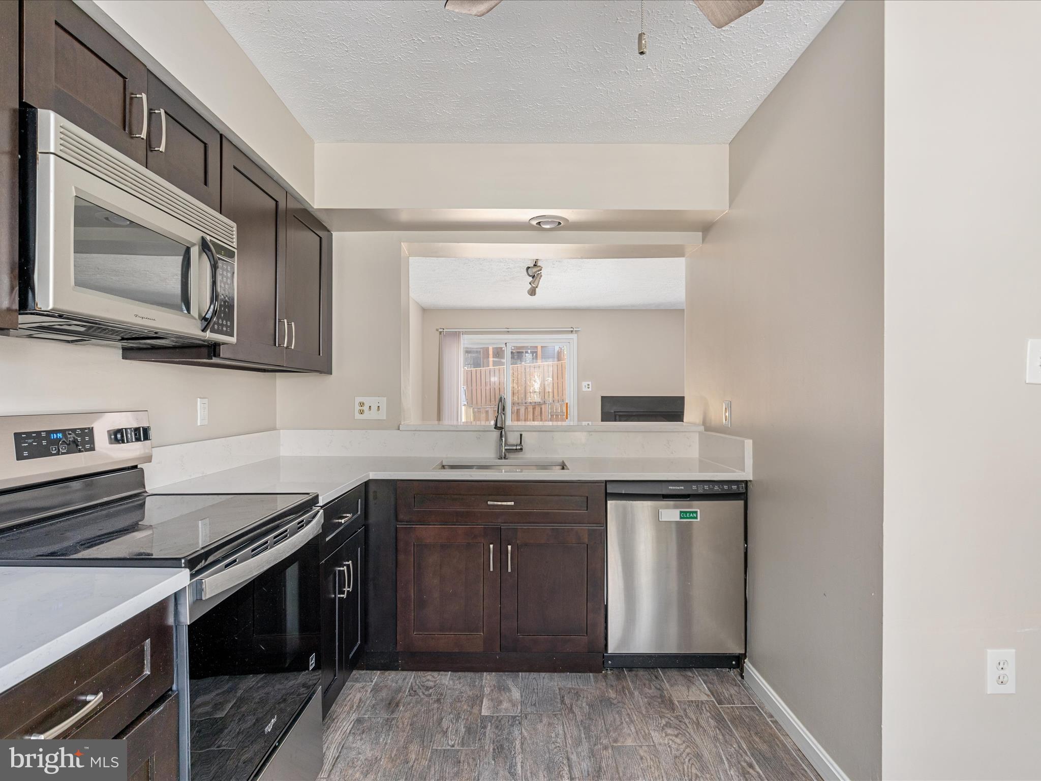 7219 Kousa Lane Springfield, VA 22152 - Photo 6 of 34 a kitchen with stainless steel appliances granite countertop a sink stove and cabinets