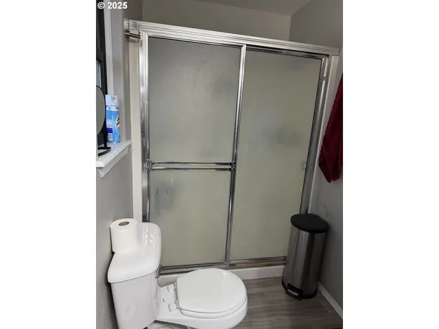 a white toilet sitting next to a shower