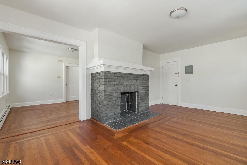46 James Street, Unit 2 Montclair, NJ 07042 - Photo 7 of 22 an empty room with wooden floor and fireplace