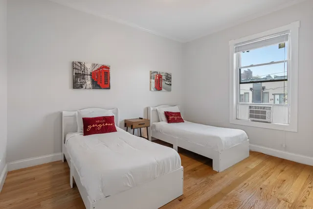 a bedroom with two beds and a window