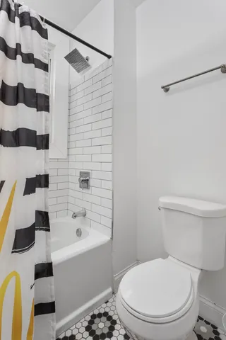 a white toilet sitting next to a bathroom sink and a shower