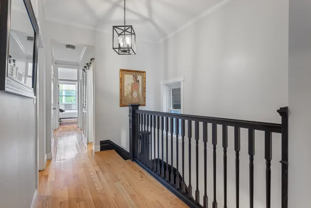 a view of a hallway with wooden floor and staircase