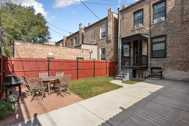 a view of a patio with table and chairs a barbeque with wooden fence