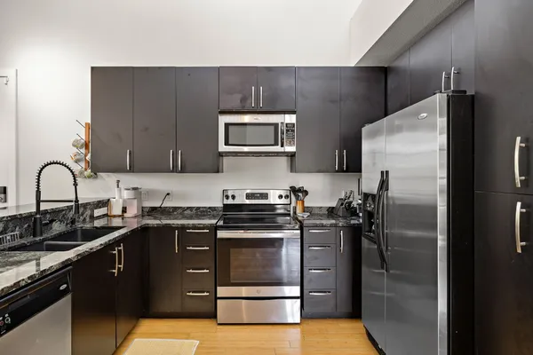 a kitchen with stainless steel appliances granite countertop a refrigerator stove and oven
