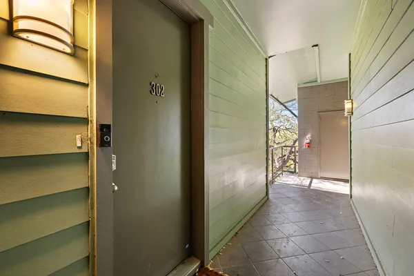 a balcony with wooden floor table and chairs