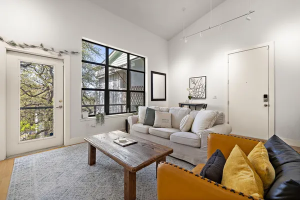 a living room with furniture a flat screen tv and a table