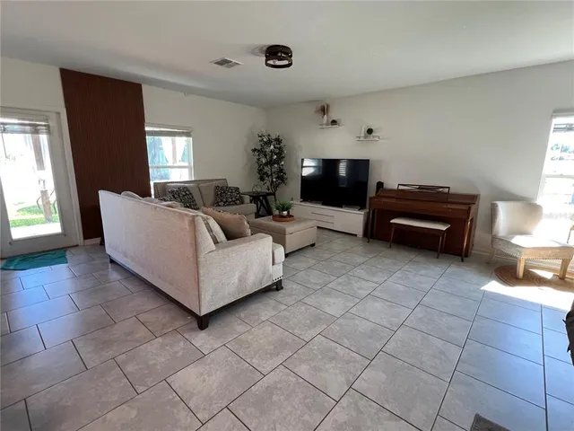 a kitchen with stainless steel appliances a stove a sink a microwave a refrigerator and white cabinets