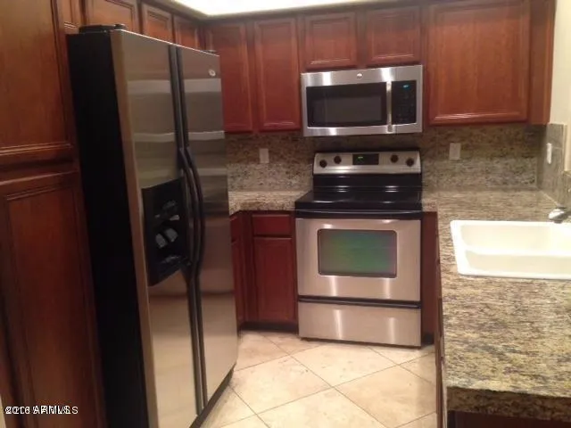 a kitchen with granite countertop a stove and a microwave