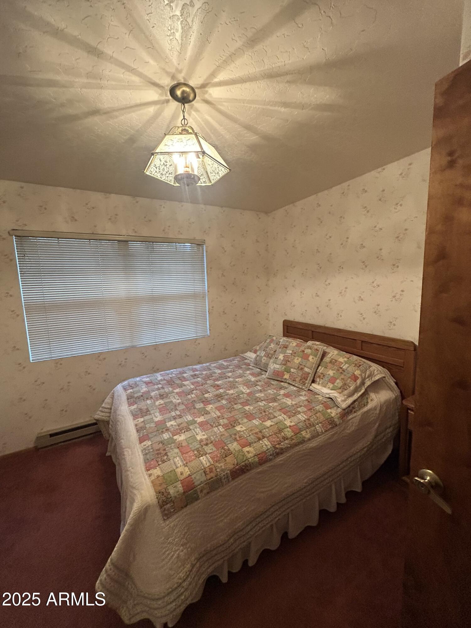 3 County Road Greer, AZ 85927 - Photo 27 of 65 a bed sitting in a bedroom next to a window