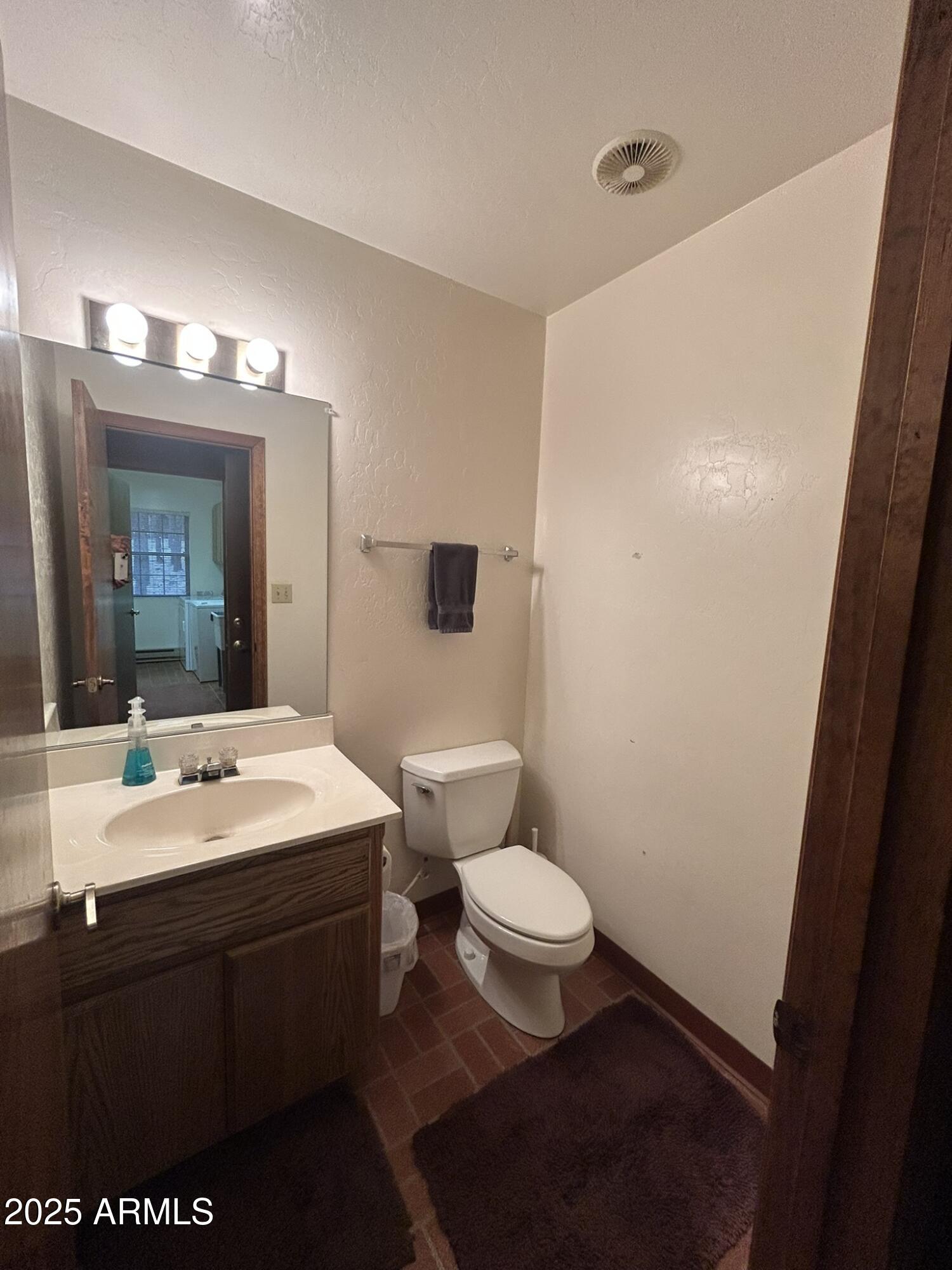3 County Road Greer, AZ 85927 - Photo 40 of 65 a bathroom with a sink toilet a mirror and vanity