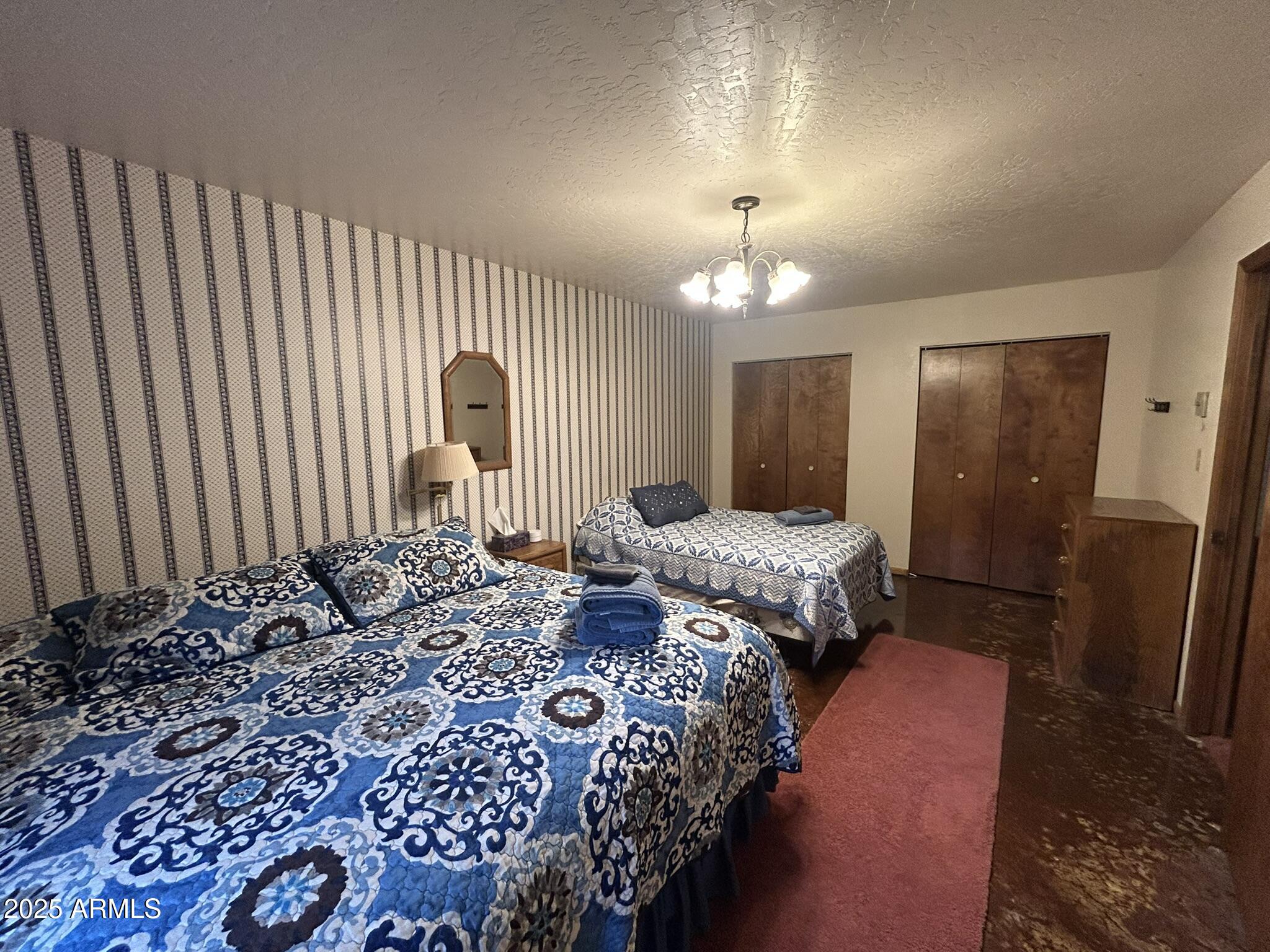 3 County Road Greer, AZ 85927 - Photo 49 of 65 a bedroom with a bed and a chandelier