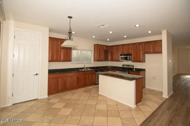 a kitchen with stainless steel appliances granite countertop a refrigerator and a sink