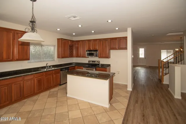 a large kitchen with granite countertop a stove a sink a refrigerator and a granite counter tops