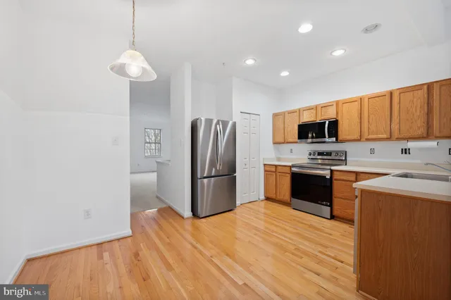 a kitchen with stainless steel appliances a refrigerator and a stove top oven