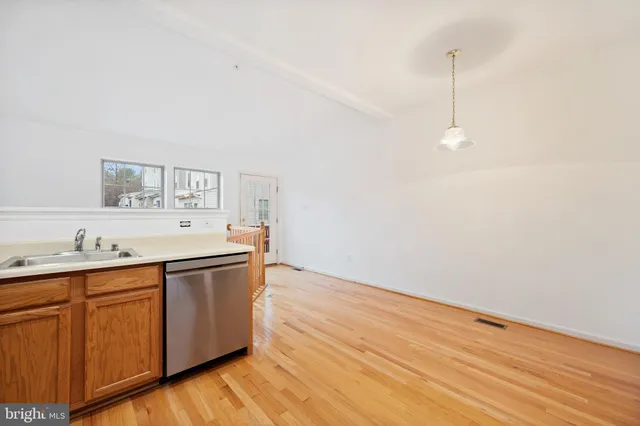a room with granite countertop a sink and a wooden floor