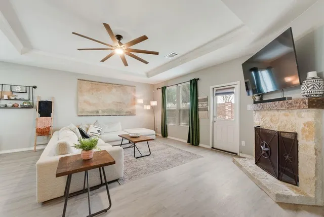 a living room with furniture a fireplace and a flat screen tv