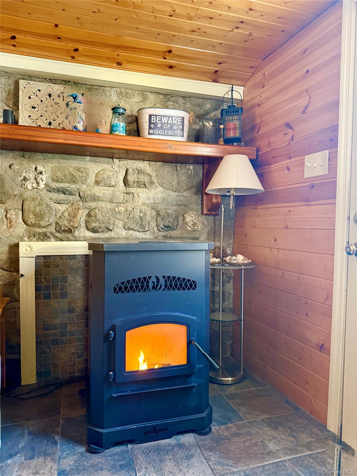 912-918 Hollow Road Salt Point, NY 12578 - Photo 25 of 35 Detailed view of wood ceiling, wooden walls, and a wood stove