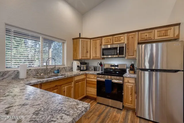 a kitchen with granite countertop a sink a stove and cabinets