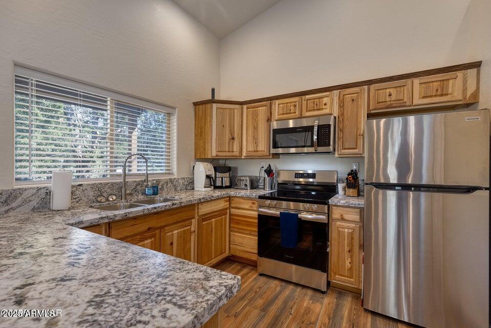 2145 Cottontail Road Overgaard, AZ 85933 - Photo 12 of 22 a kitchen with stainless steel appliances granite countertop a refrigerator a sink dishwasher a stove top oven a refrigerator with wooden floor