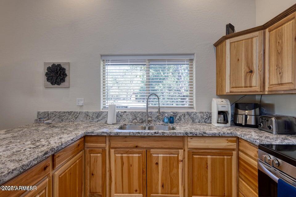 2145 Cottontail Road Overgaard, AZ 85933 - Photo 13 of 22 a kitchen with granite countertop a sink a stove and cabinets