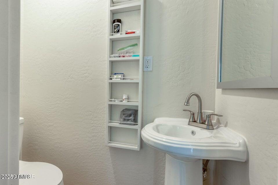 2145 Cottontail Road Overgaard, AZ 85933 - Photo 17 of 22 a bathroom with a sink a toilet and a mirror