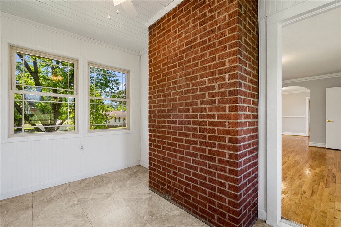 1509 869 Anderson, SC 29621 - Photo 32 of 45 A bright space offers views of surrounding greenery through large windows, showcasing a distinct brick feature wall.