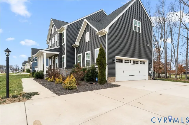 a view of a white house with a large tree in front of it