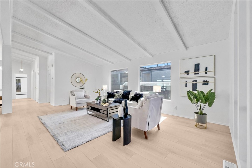 21650 Temescal Canyon Road, Unit 26 Corona, CA 92883 - Photo 13 of 32 a living room with furniture potted plant and wooden floor