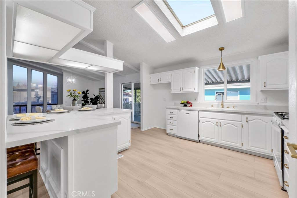 21650 Temescal Canyon Road, Unit 26 Corona, CA 92883 - Photo 18 of 32 a kitchen with kitchen island white cabinets and white appliances