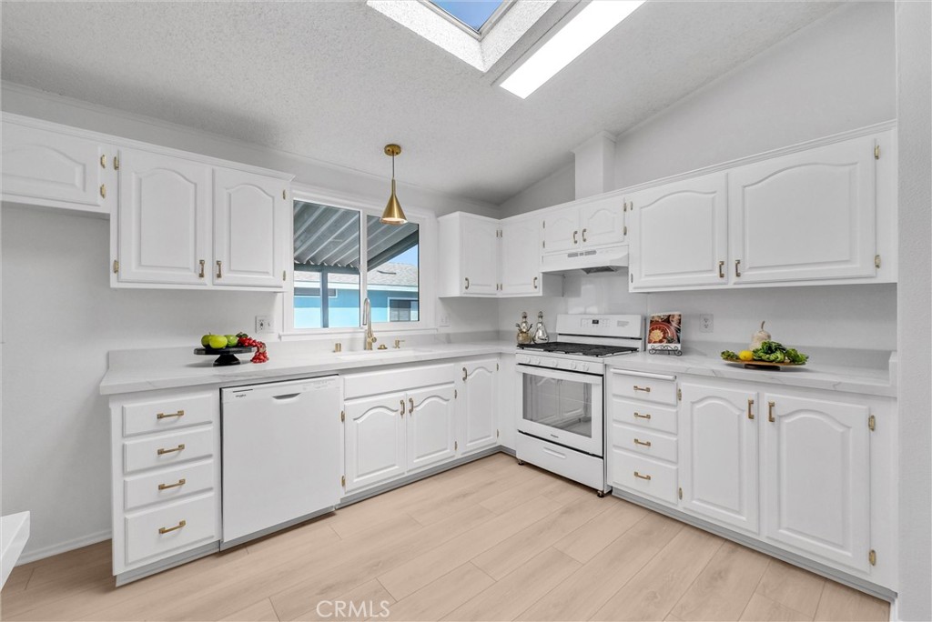 21650 Temescal Canyon Road, Unit 26 Corona, CA 92883 - Photo 20 of 32 a kitchen with granite countertop white cabinets and white appliances