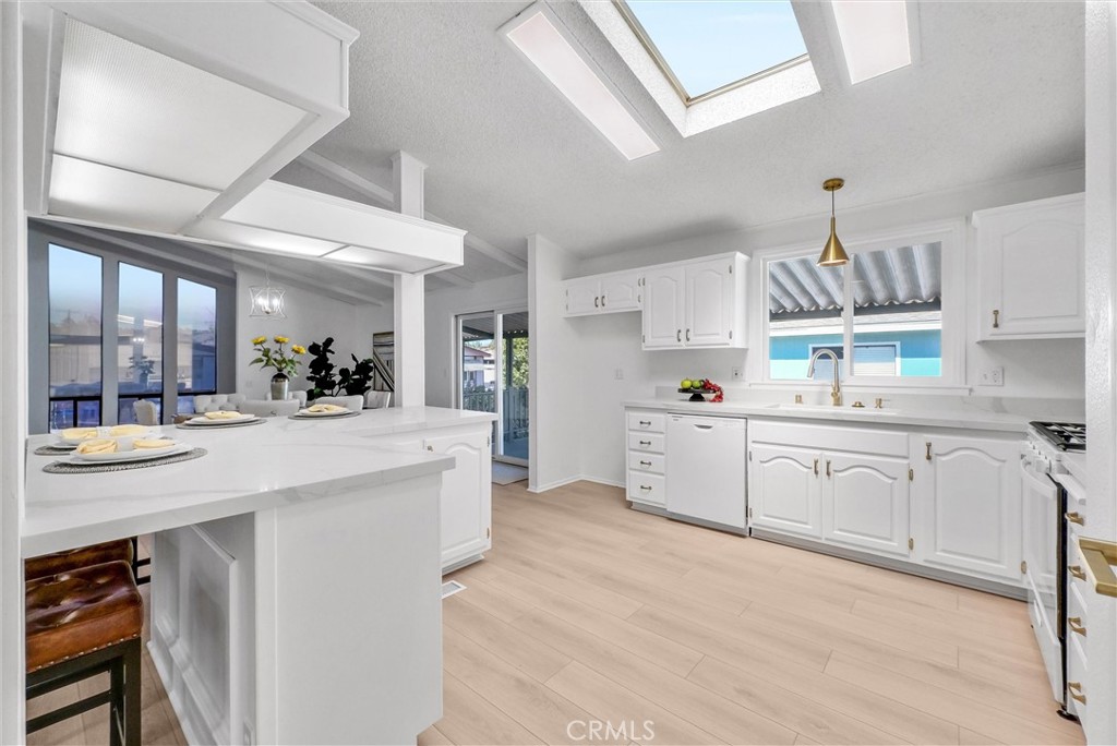 21650 Temescal Canyon Road, Unit 26 Corona, CA 92883 - Photo 2 of 32 a kitchen with kitchen island white cabinets and white appliances