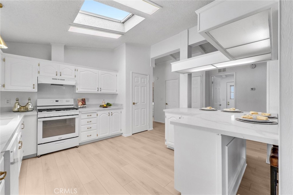 21650 Temescal Canyon Road, Unit 26 Corona, CA 92883 - Photo 21 of 32 a kitchen with granite countertop a sink and white cabinets