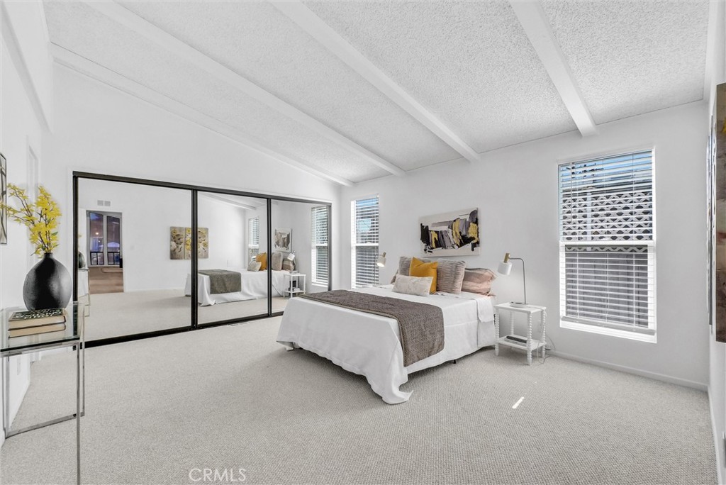 21650 Temescal Canyon Road, Unit 26 Corona, CA 92883 - Photo 24 of 32 a spacious bedroom with a bed couch and window