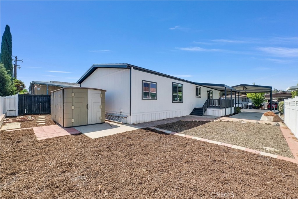 21650 Temescal Canyon Road, Unit 26 Corona, CA 92883 - Photo 30 of 32 a front view of a house with a yard and garage