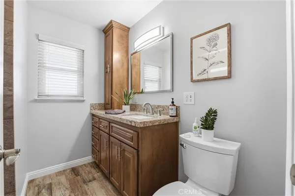 a bathroom with a granite countertop toilet sink and mirror