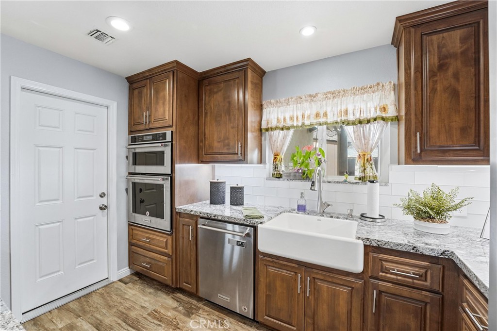 544 Firethorne Street Brea, CA 92821 - Photo 5 of 39 Large farmhouse sink, granite countertops, stainless steel appliances, and direct access to the 2 car garage and laundry area!