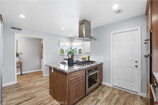a kitchen with stainless steel appliances granite countertop a sink stove and wooden floor