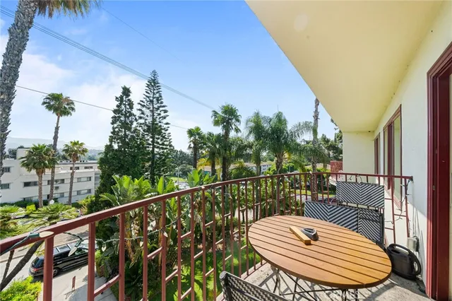 a balcony with wooden floor and some chairs