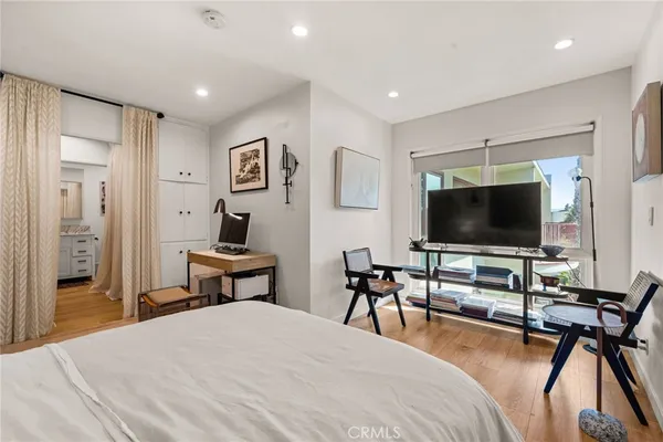 a bedroom with a bed and a flat screen tv