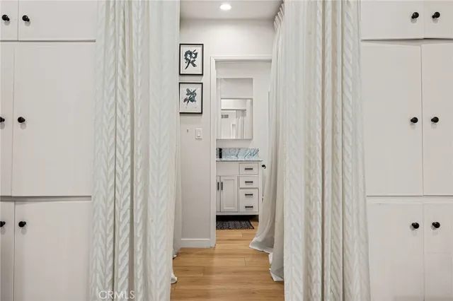 a view of a hallway with wooden shelves