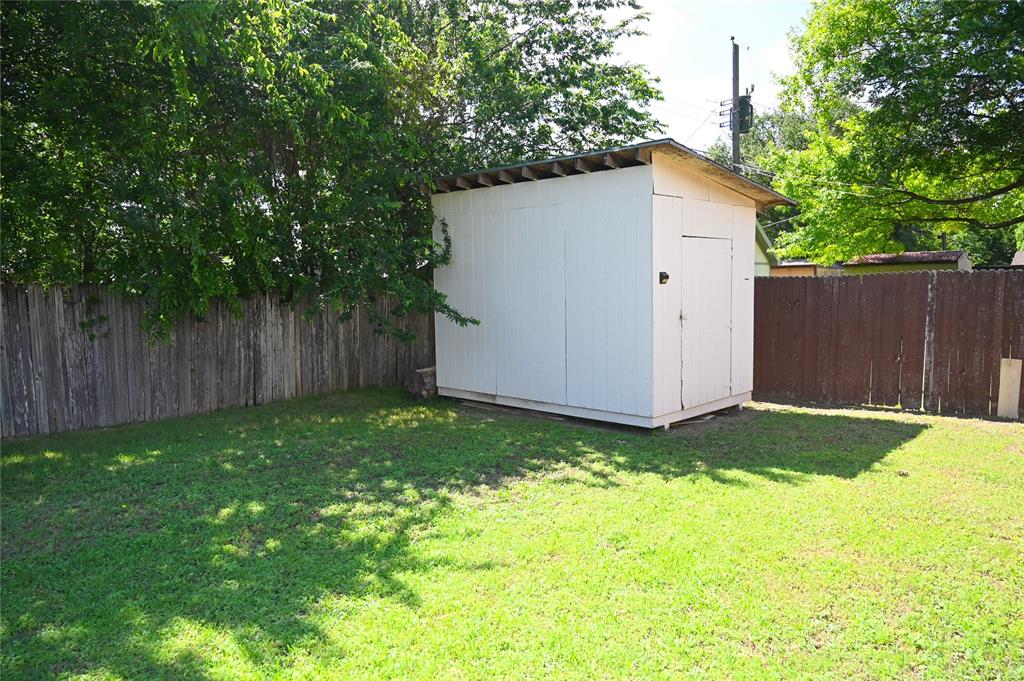 1352 Simpson Drive Hurst, TX 76053 - Photo 15 of 40 Expansive grassy yard with a white storage shed and wood-fencing