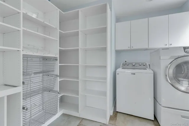 a utility room with cabinets washer and dryer