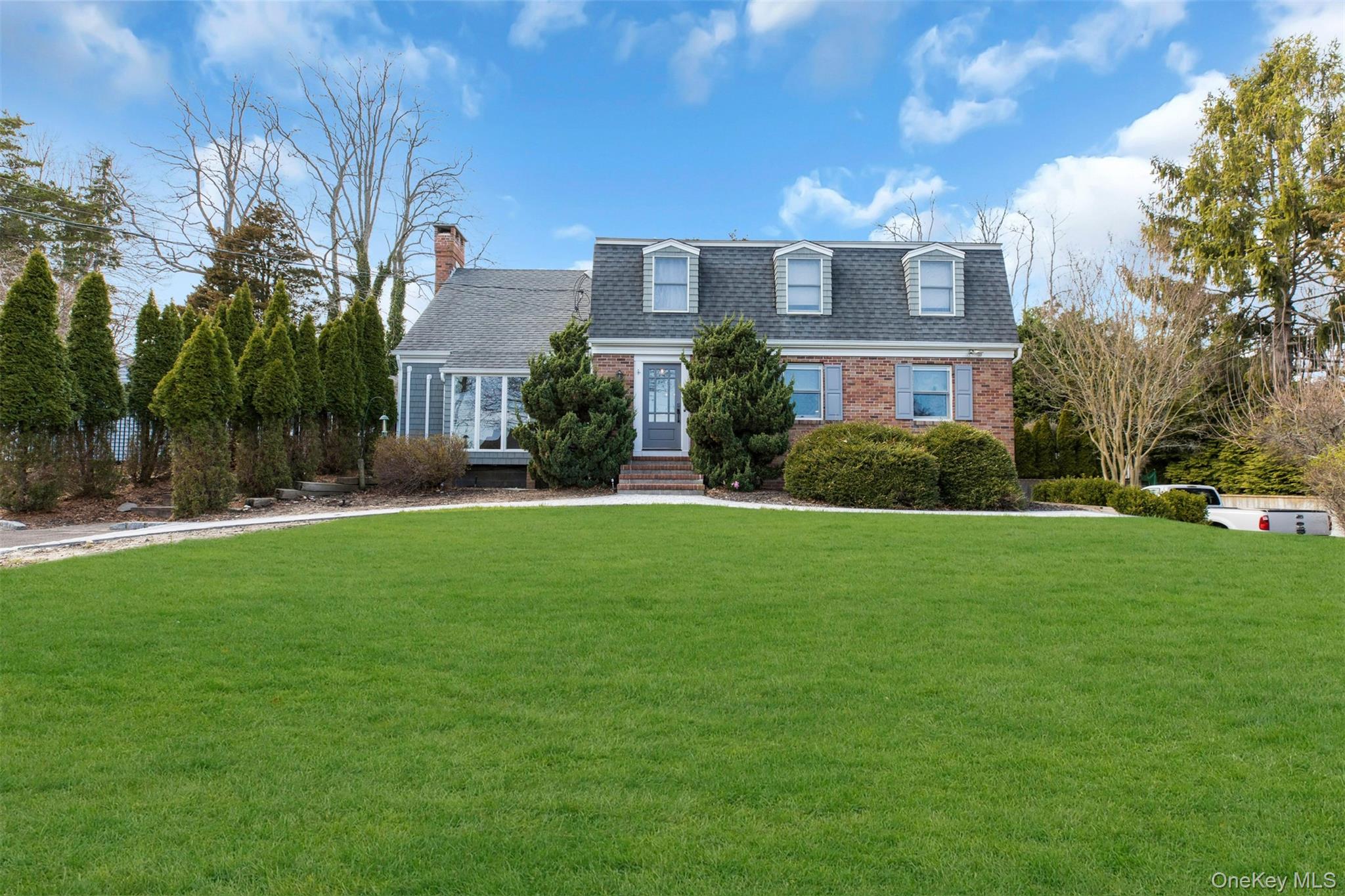 345 Colonial Road Southold, NY 11971 - Photo 2 of 31 a front view of house with yard and green space