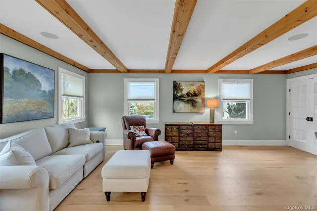 a large white kitchen with kitchen island a stove a refrigerator a dining table and chairs with wooden floor