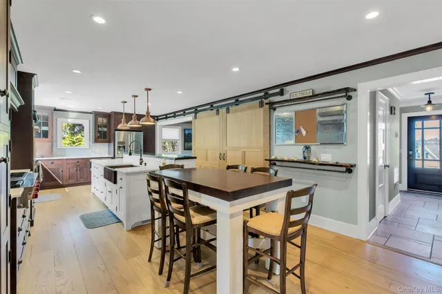 a kitchen with stainless steel appliances kitchen island granite countertop a table chairs sink and cabinets